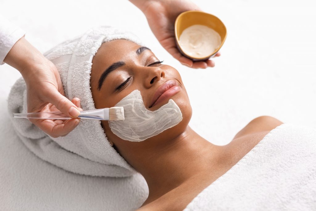 Vue de dessus d'une esthéticienne appliquant un masque facial